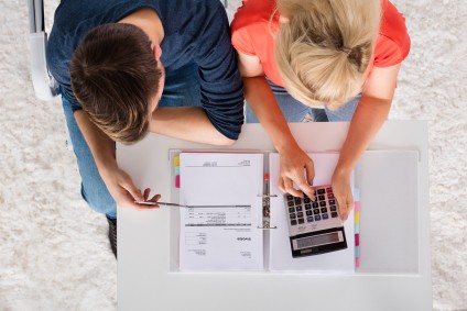 Couple with calculator choosing mortgage rates. Lock in mortgage rates