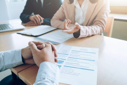 A couple talking to a proffesional with paperwork