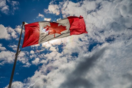 Canada flag flapping in the wind. Buying Canadian real estate