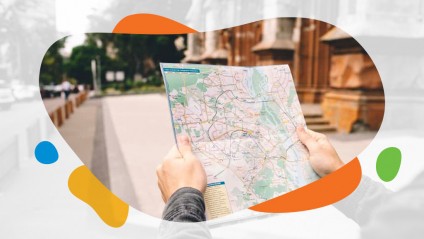 A male in a city holding out a map