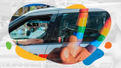 A Durham police car painted with a hand giving the piece sign with rainbow paint