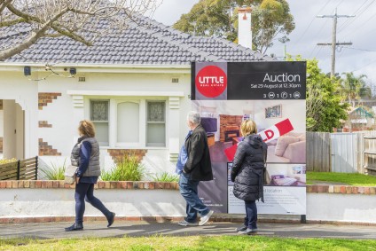 People touring open house sold sign on lawn
