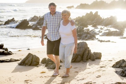 Couple walks along beach discussing tax deductions as a married couple.