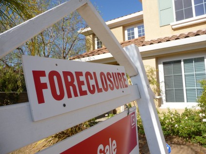 A foreclosure sign sitting in front of a house