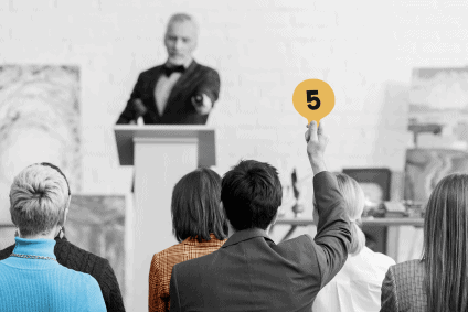 man raising placard during an auction