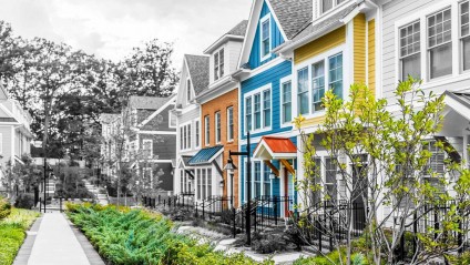 Row of brightly colored houses with vibrant foliage in front