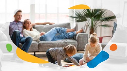 Mother and father on a couch with children playing on the floor