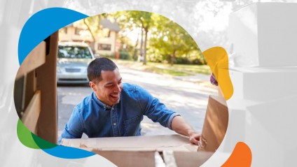 A smiling man moving boxes out of a van