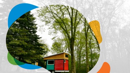 A red, green and natural wood tiny home in a forest