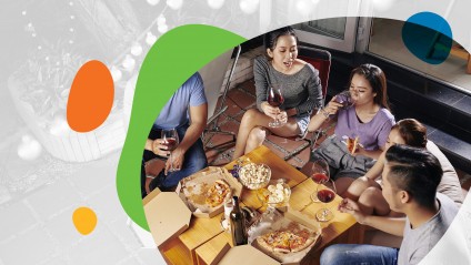 Friends enjoy dinner on patio with twinkly lights