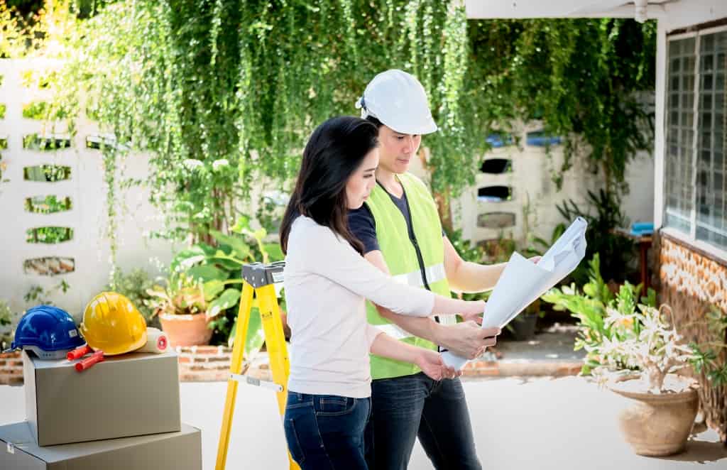 looking at a blueprint to discuss about renovating the old house to be new home, to Real estate and renovation concept