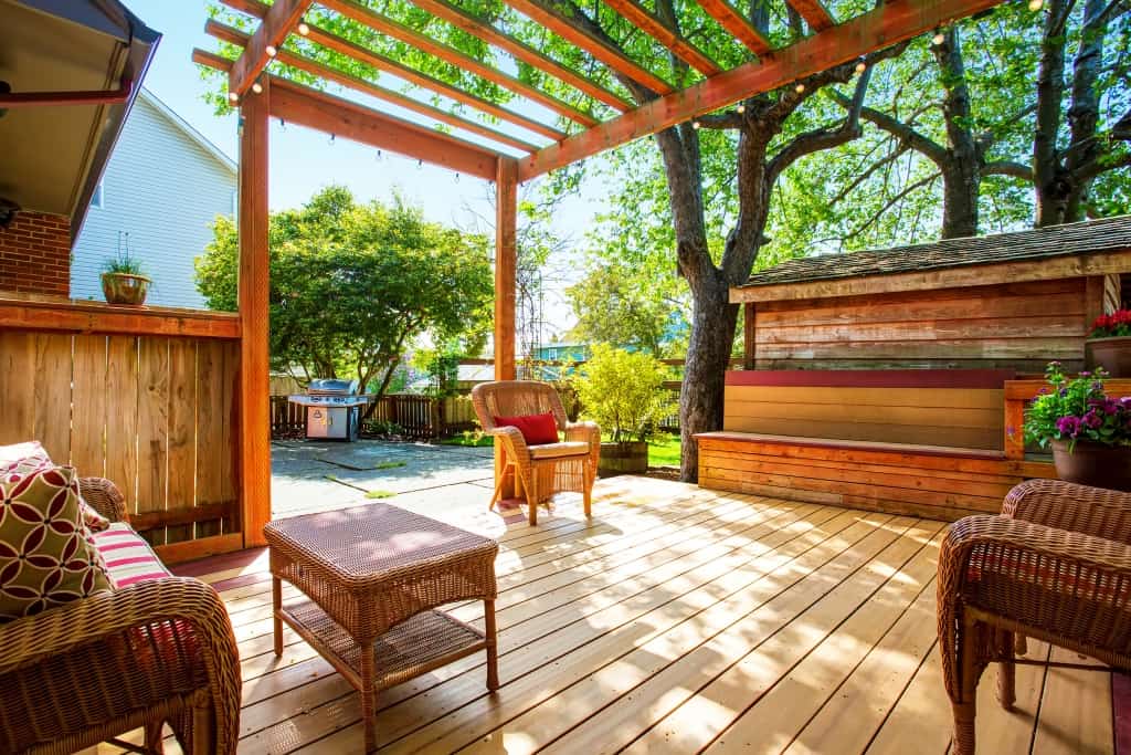 Backyard deck with wicker furniture and pergola