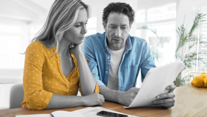 couple-reading-through-paperwork-together-in-their-living-room