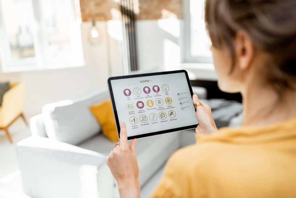Controlling smart home devices using a digital tablet with launched application. Smart home concept