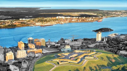 Aerial view of a large waterway with ships splitting a city near the ocean.