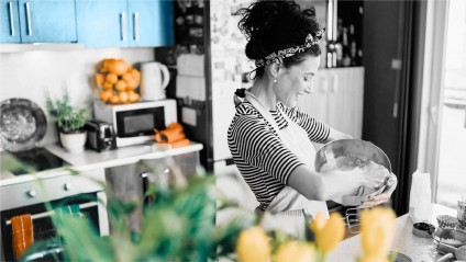 A female in a bright kitchen preparing ingredients for a pie.