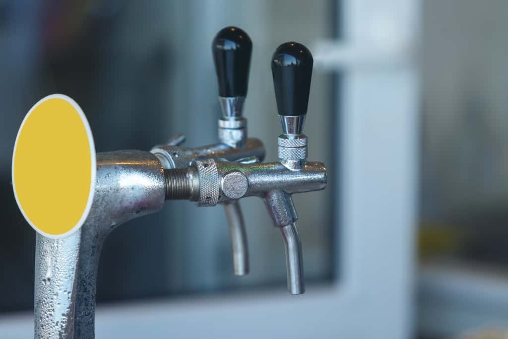 Two steaming taps for pouring beer. Close up. Condensation drops close up