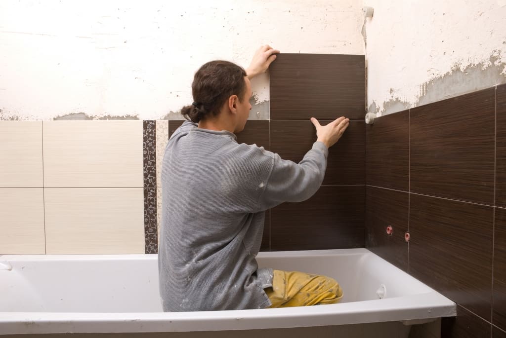 Man tiling a wall in the bathroom