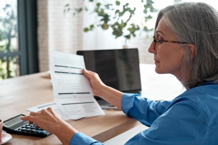 Older woman checks report at her home office