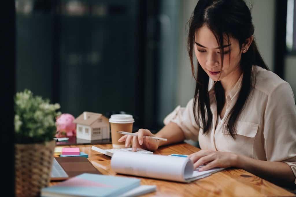 young asian woman working on expenses