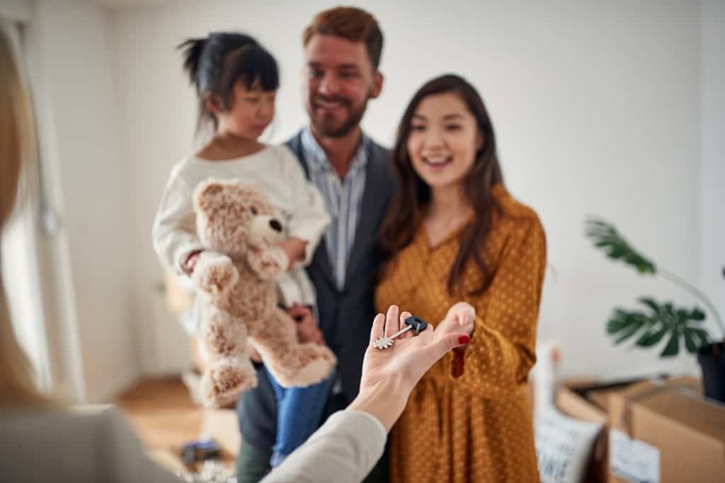 a woman hands a family a key