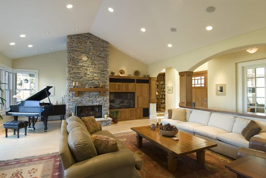 A well lit open-concept living area with a fireplace and piano