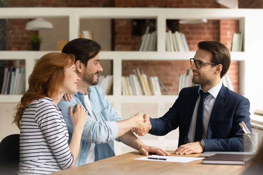 Couple handshake mortgage officer, accepting bank loan terms and rates