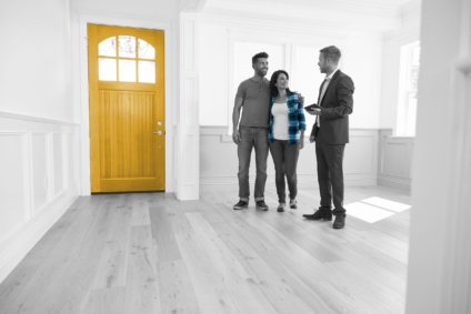 Real estate agent talks to couple in an empty house