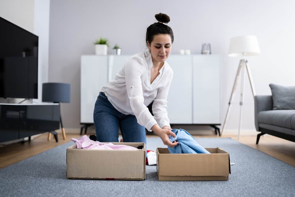 Woman Decluttering Clothes, Sorting And Cleaning Up