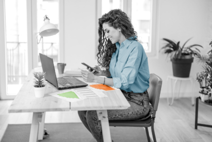 woman sitting at desk on her phone