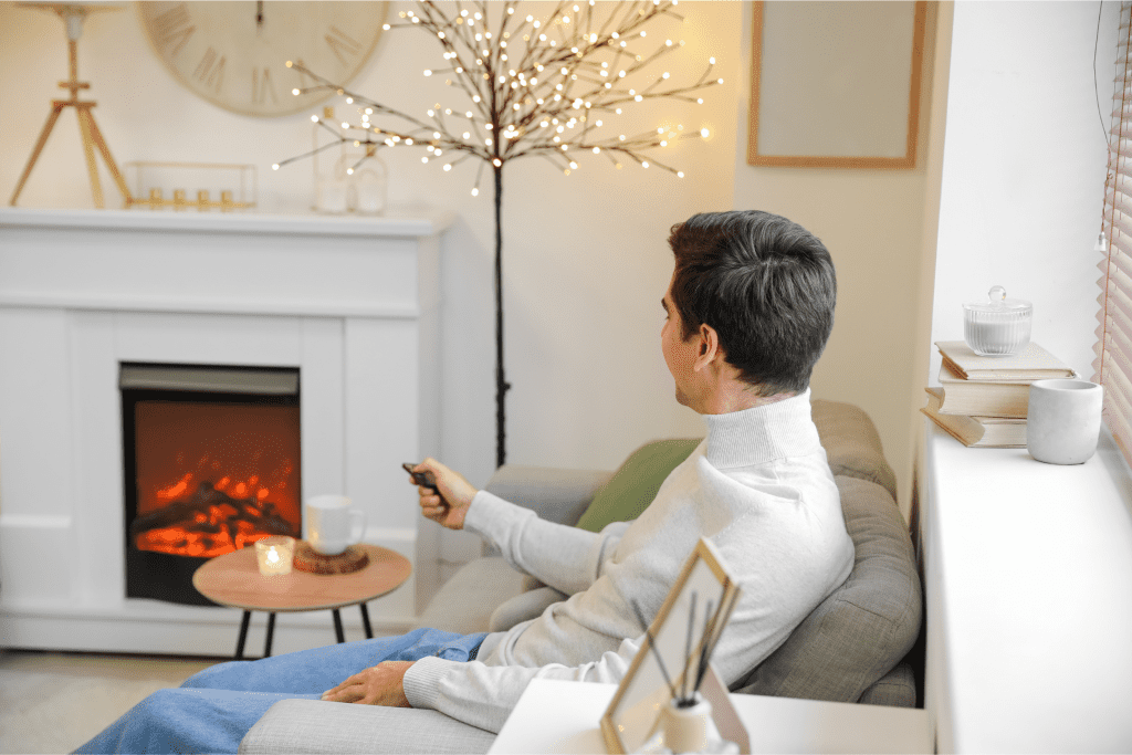 man turning on electric fireplace