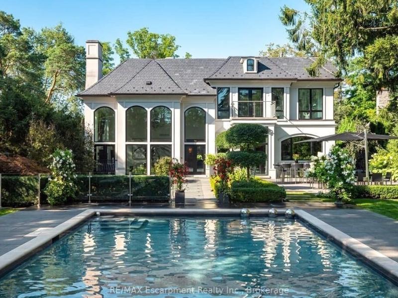 limestone mansion surrounded by trees, A pool is in the foreground