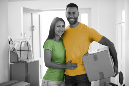 young male/female couple standing in house with boxes