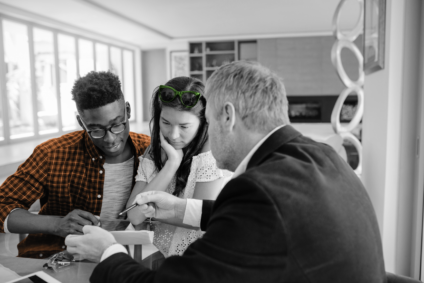 Couple looks over paperwork with real estate professional
